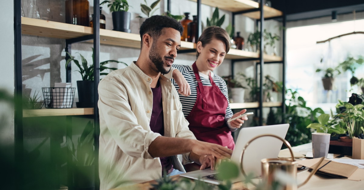 assistant in plant shop using laptop 