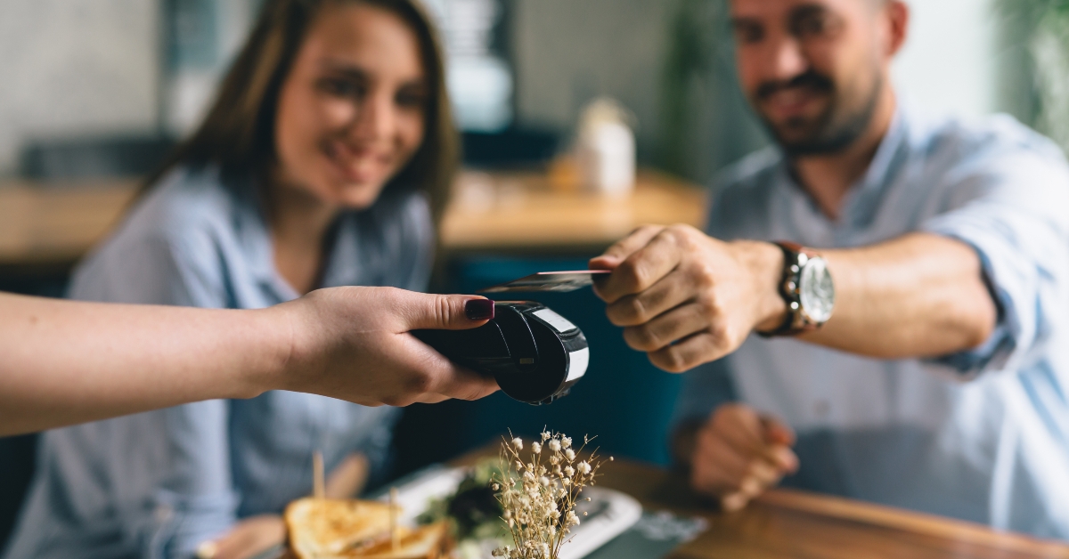 man making payment with smartphone in restaurant 