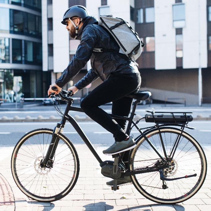 male courier with bicycle delivering packages in city