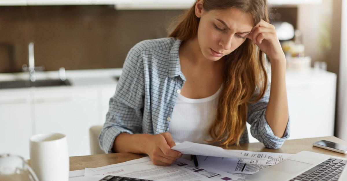Woman in open kitchen reviewing bill