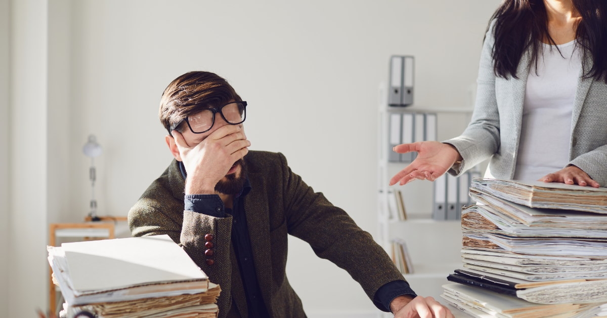 man appears stressed while working at his desk in the office