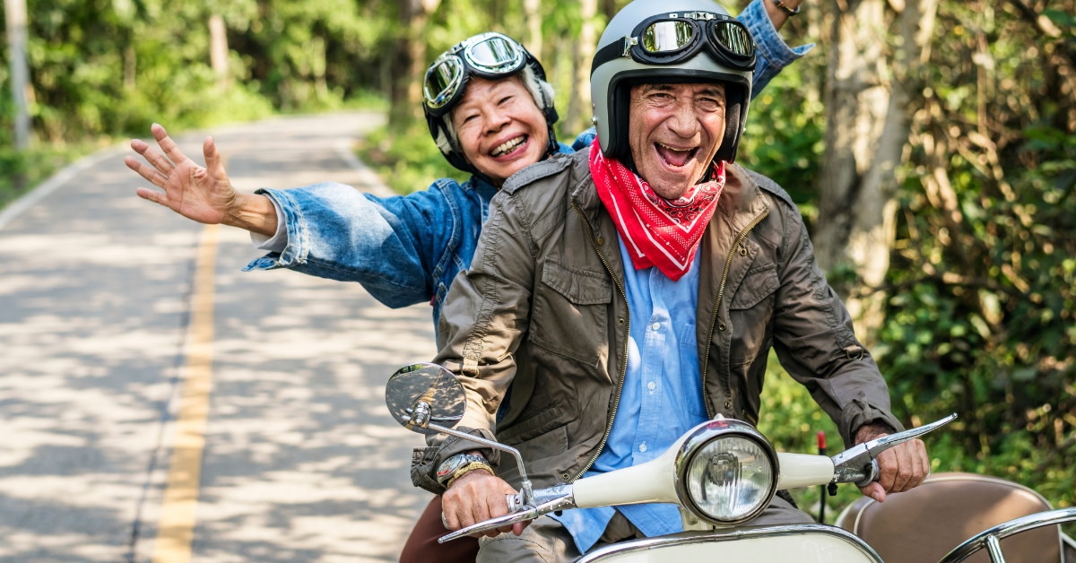 senior couple on a scooter ride amidst lush green forests