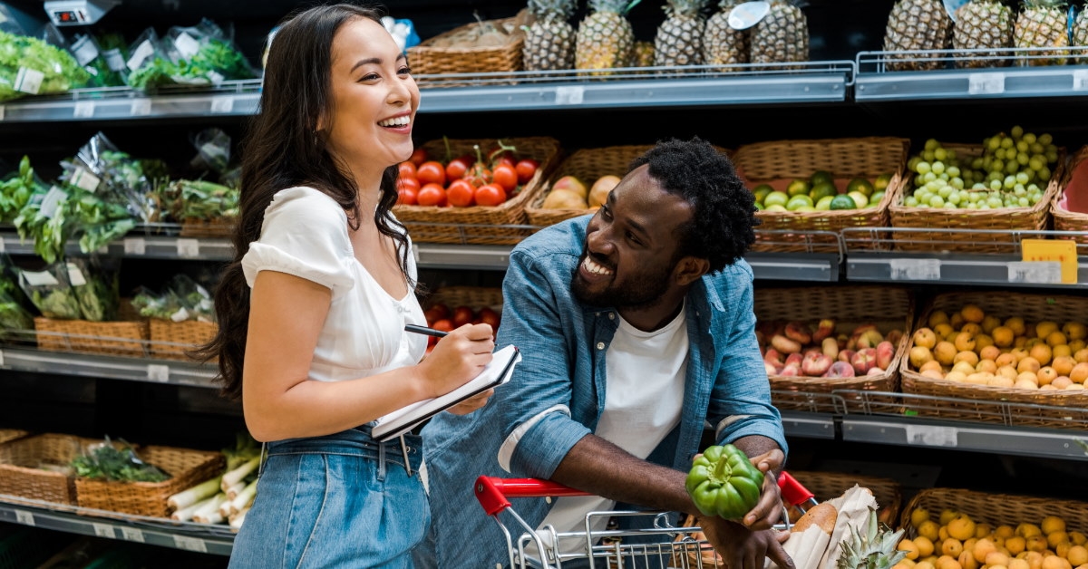 couple doing grocery shopping and making notes of products