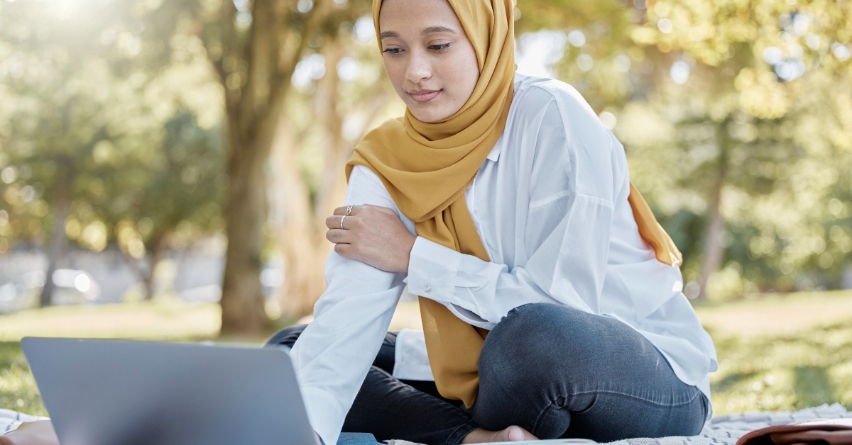 student with laptop in park for elearning