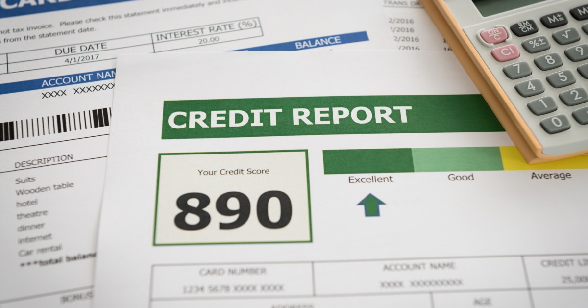 calculator placed on papers with credit score and card statement on table