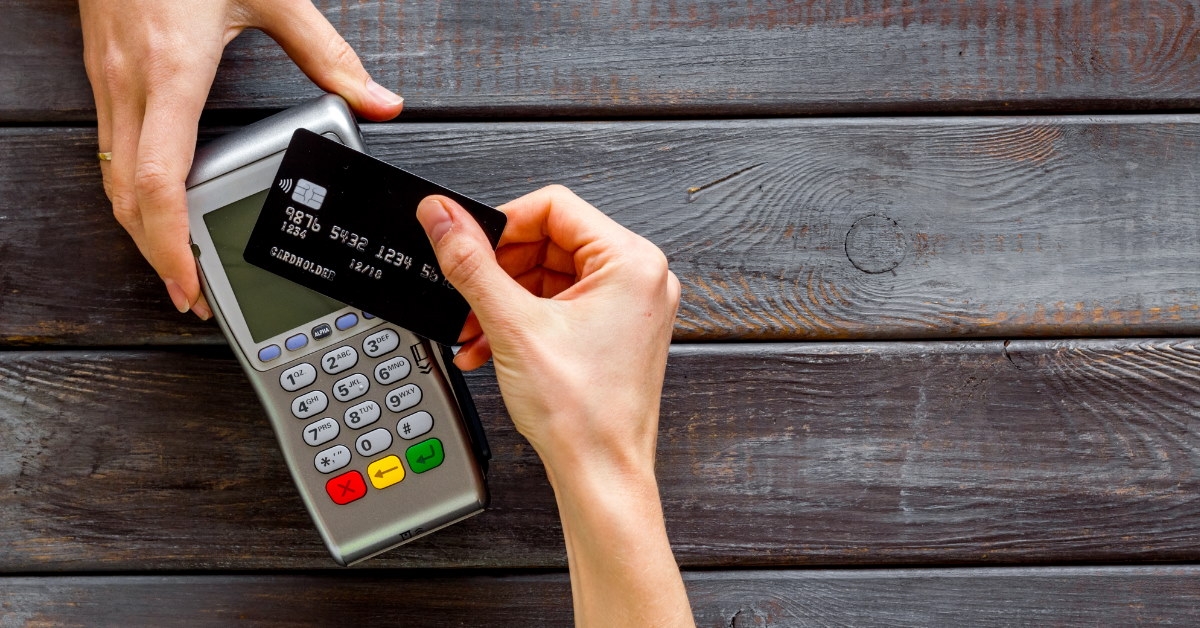holding card to make payment using pos terminal