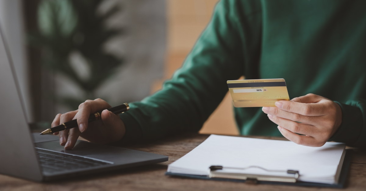 man using card to make online payment using laptop