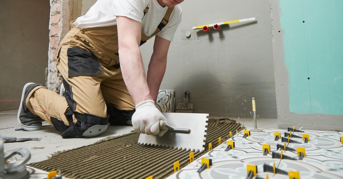 tiler installing tile on bathroom floor