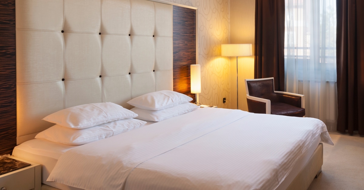 beautiful interior of hotel room with LCD bed and lamps during day time