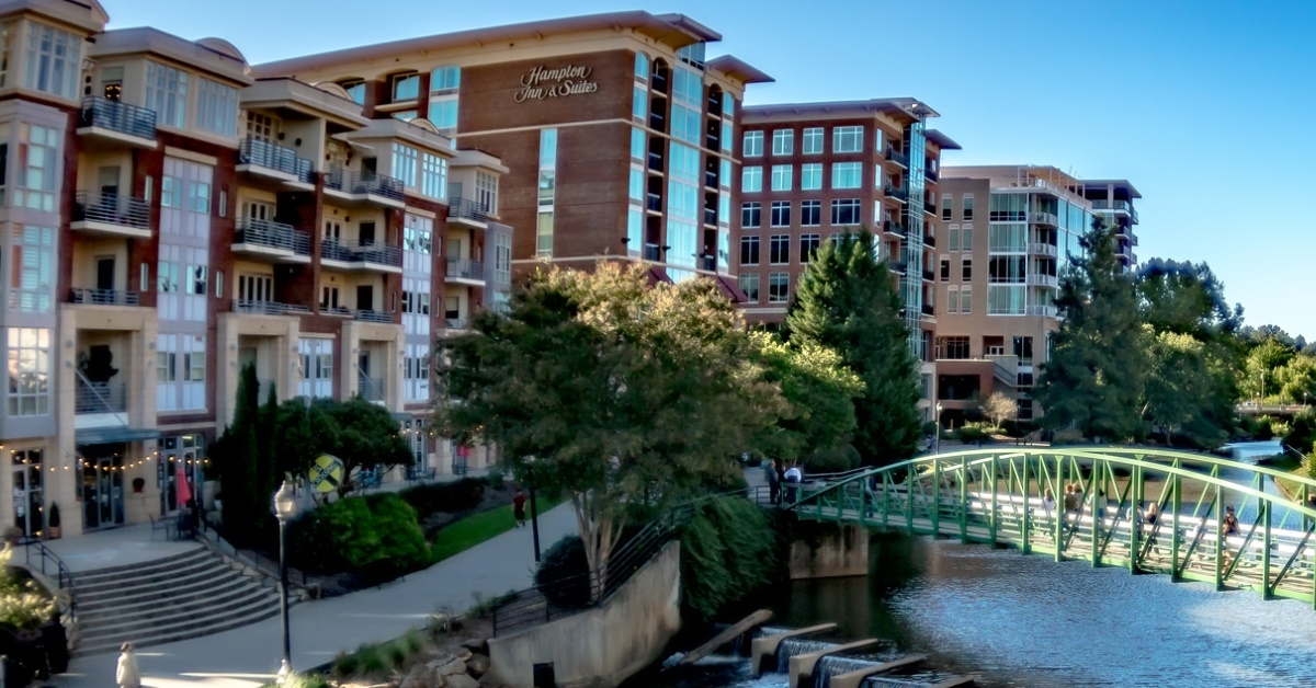 bridge on reedy river with buildings in south carolina during day time