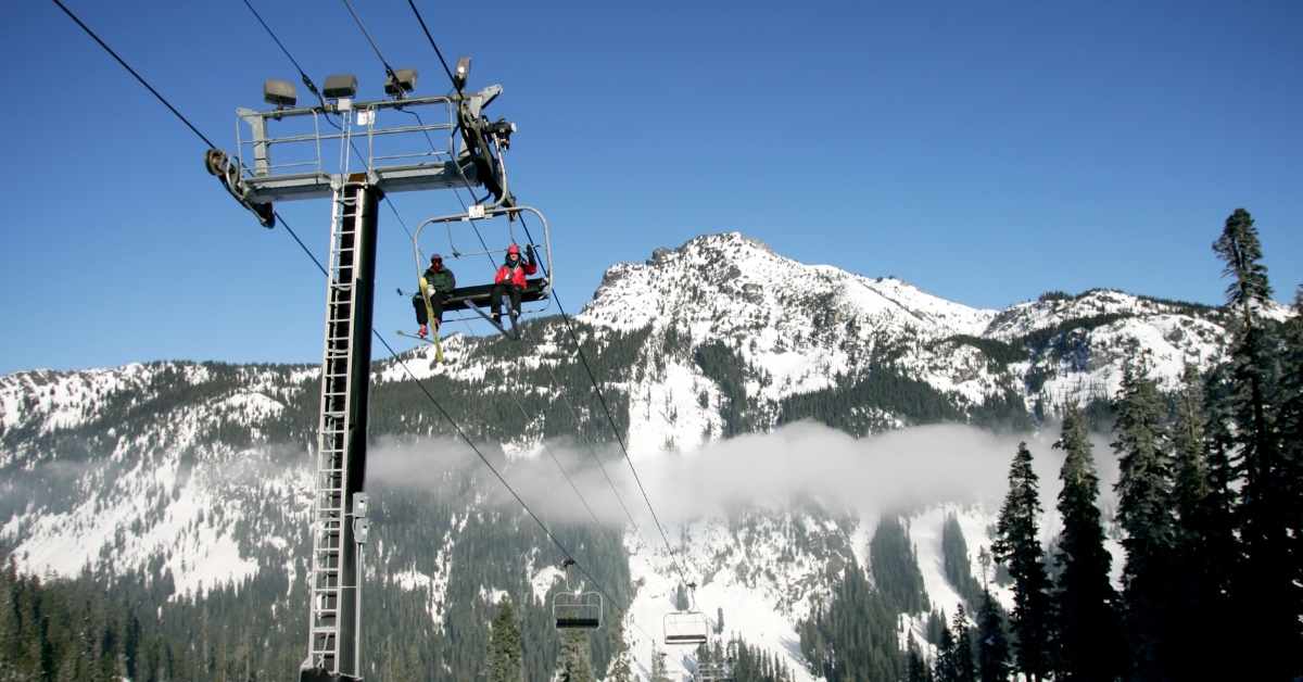chairlift having tourists in mountains full of snow