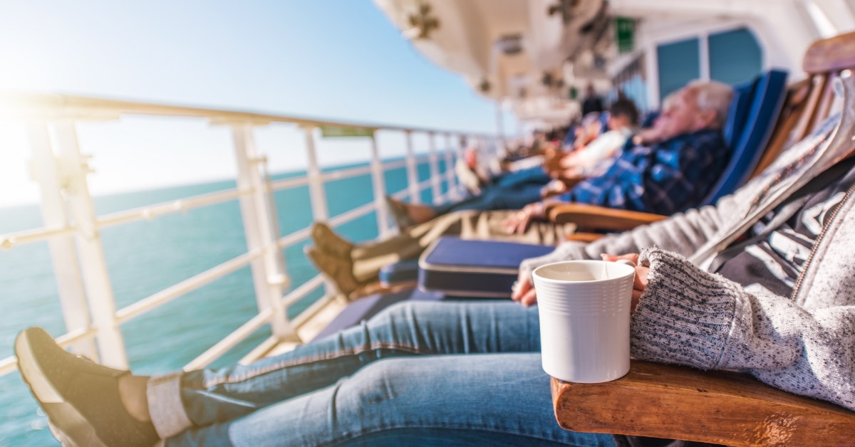 tourists relaxing on deck chairs in sun at cruise ship
