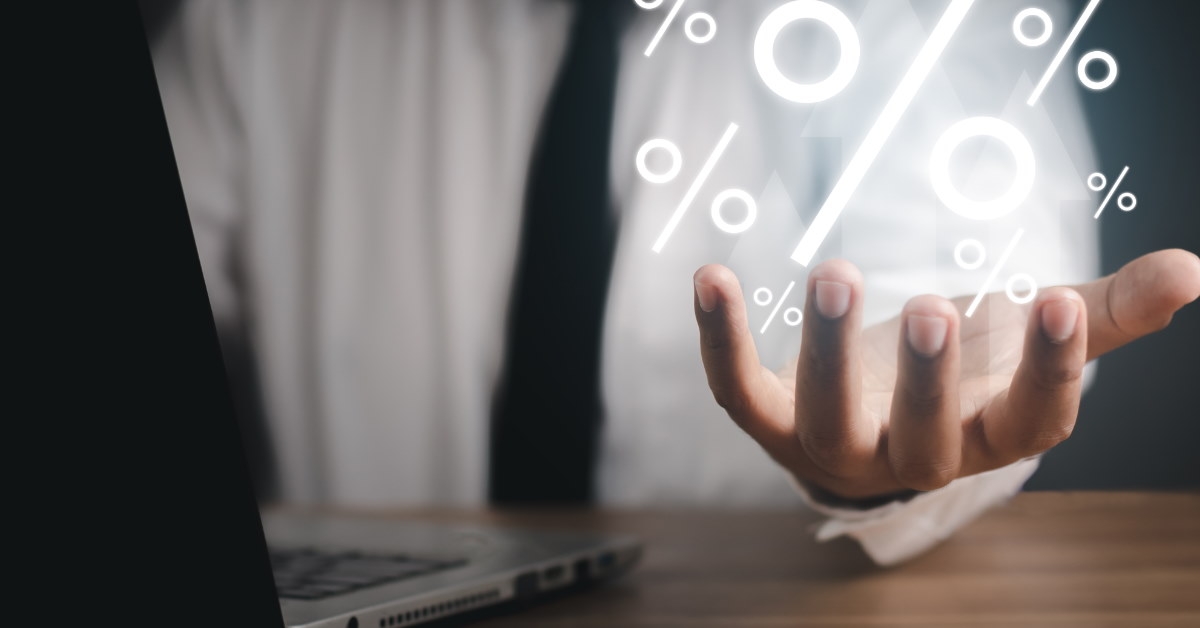 man holding 3d percentages in hand while using laptop 