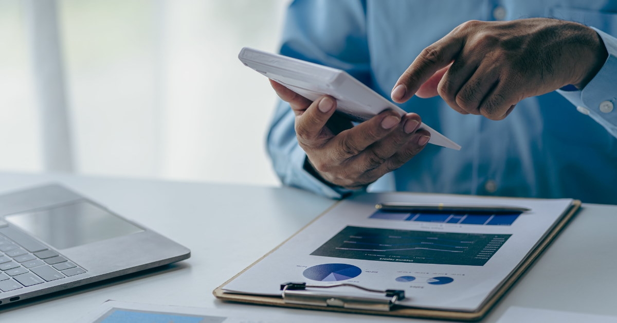 male accountant sitting at table using calculator to calculate finance