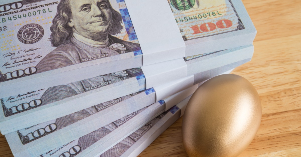 table having one hundered dollar bank notes along with golden egg