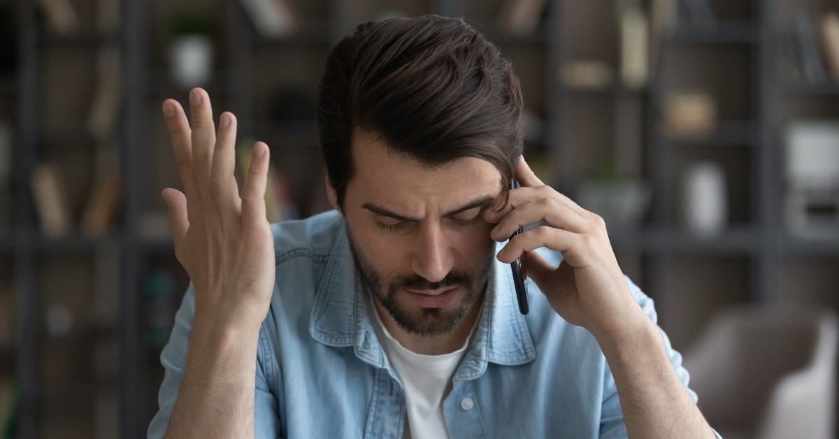 unhappy businessman talking on smartphone