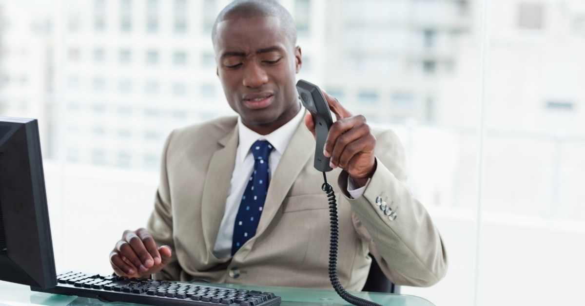 african american businessman at office hanging up phone on table