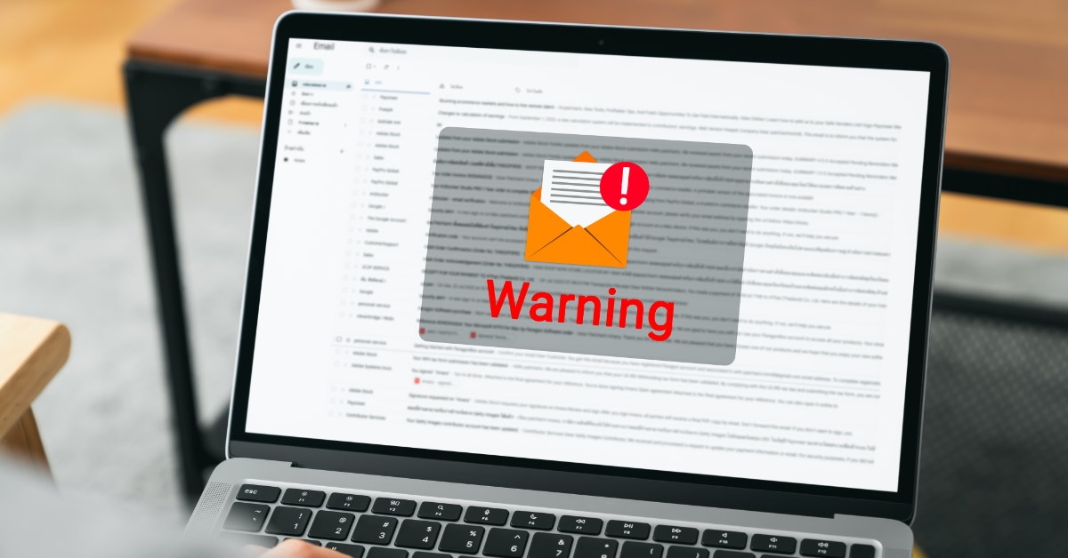 man using laptop with warning pop-up on screen.