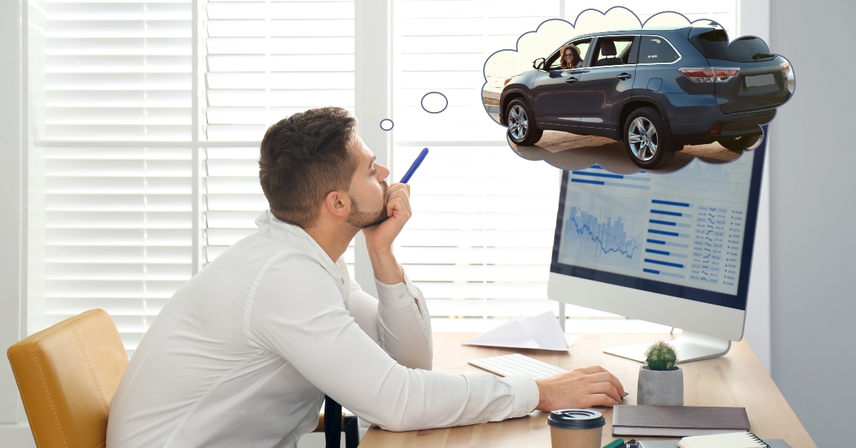 man dreaming about new car in office