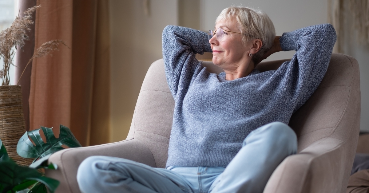 senior woman resting seated on coach