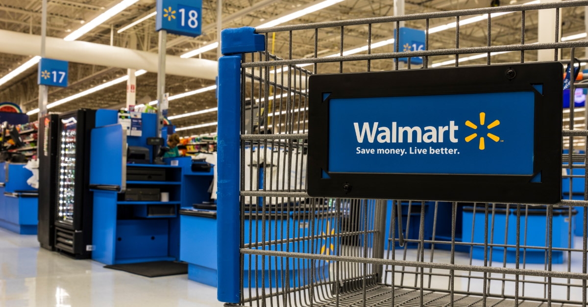 walmart logo on shopping cart standing inside walmart 