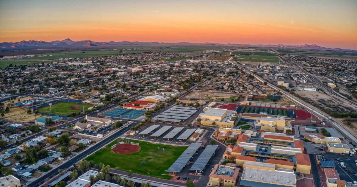 aerial view of phoenix suburb with buildings and green parks at sunset