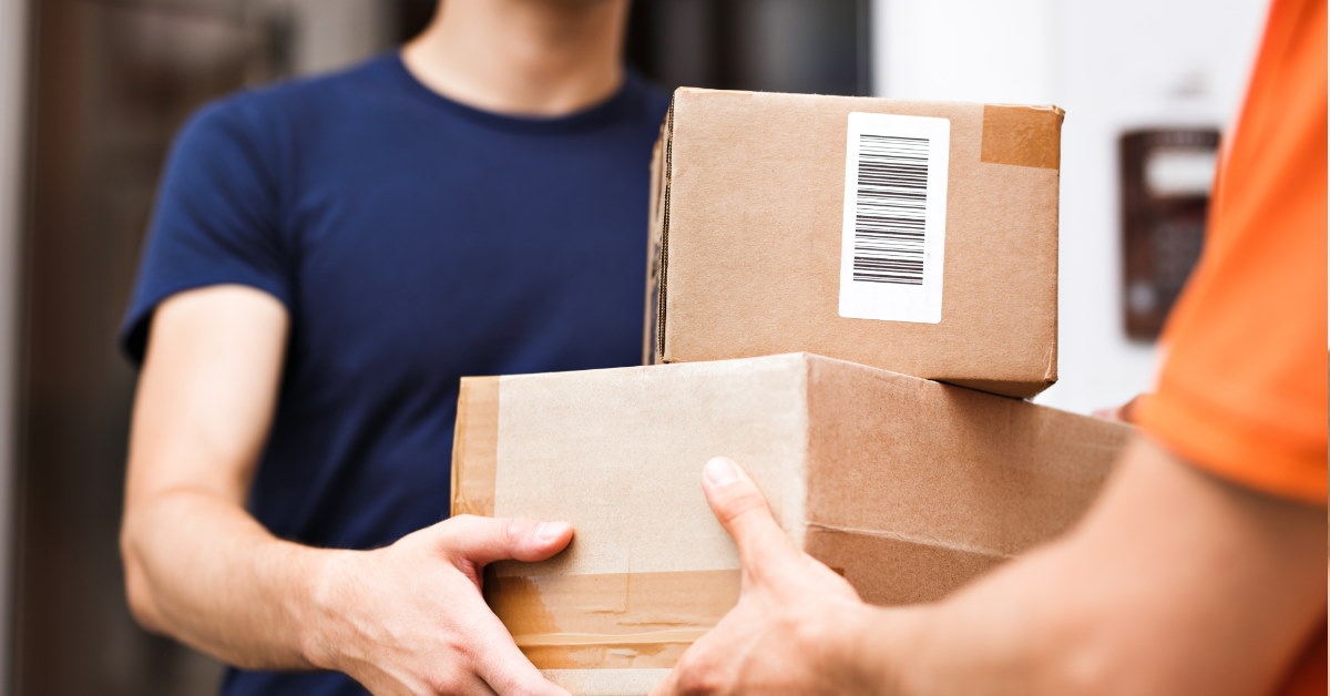 man standing at door receiving parcels from delivery boy