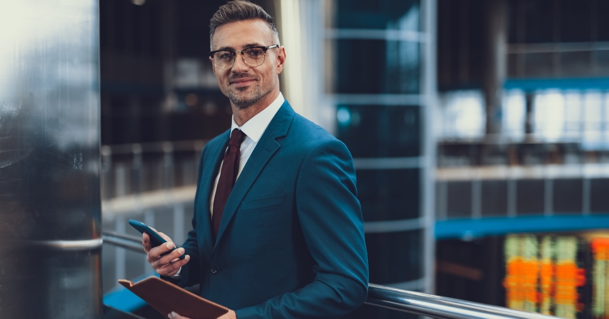man with documents and cellular phone