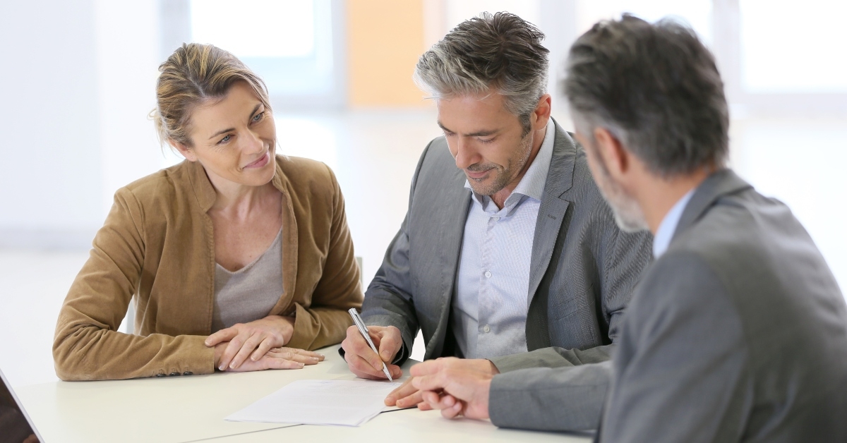 mature couple signing financial contract at the bank