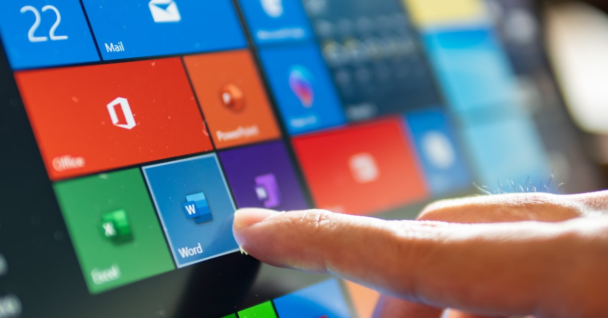 man using touch screen laptop to click microsoft word 