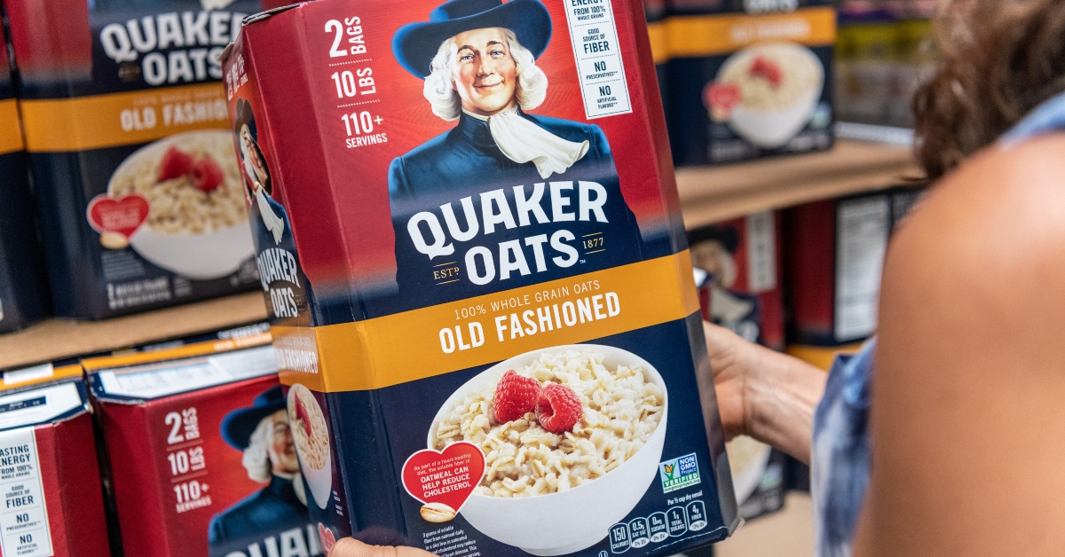 shoppers hand holding a box of Quaker Oats