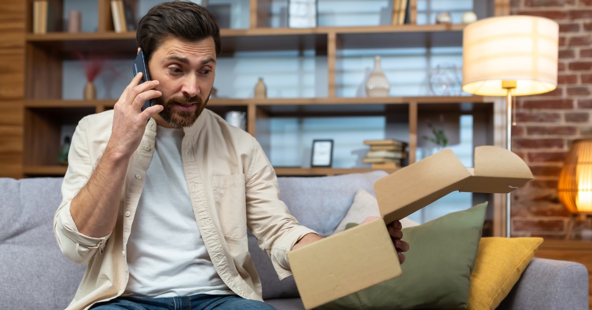 man talking to customer support on smartphone complaining about parcel in hand