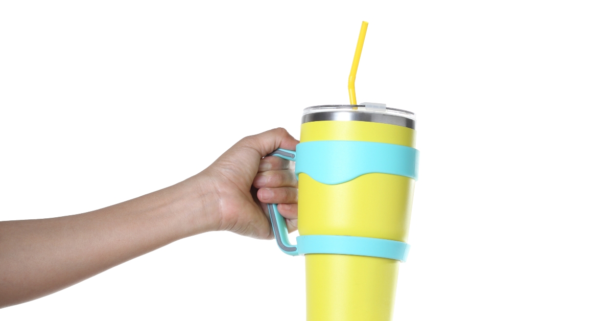 hand holding stainless steel thermos mug