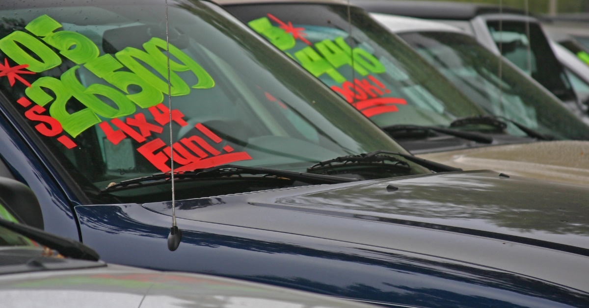 rows of cars ready for sale in parking during day time