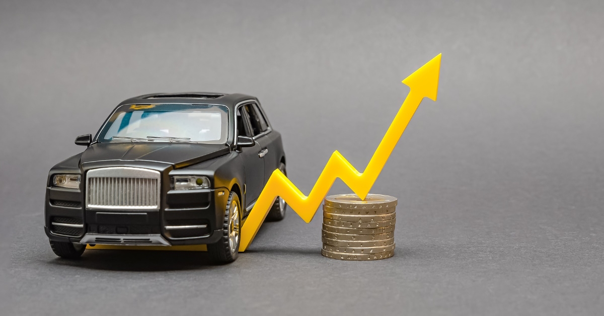 toy car placed on table along with stack of pennies and arrow showing concept of rising cost of new cars