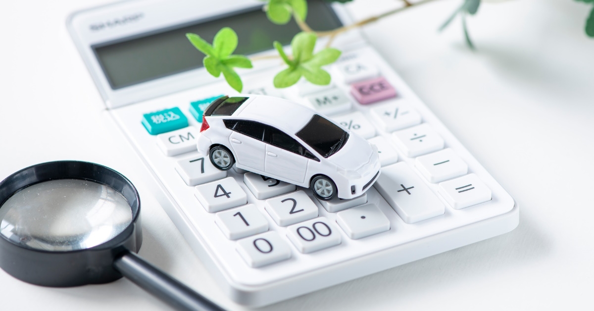 toy car on calculator with magnifying glass 