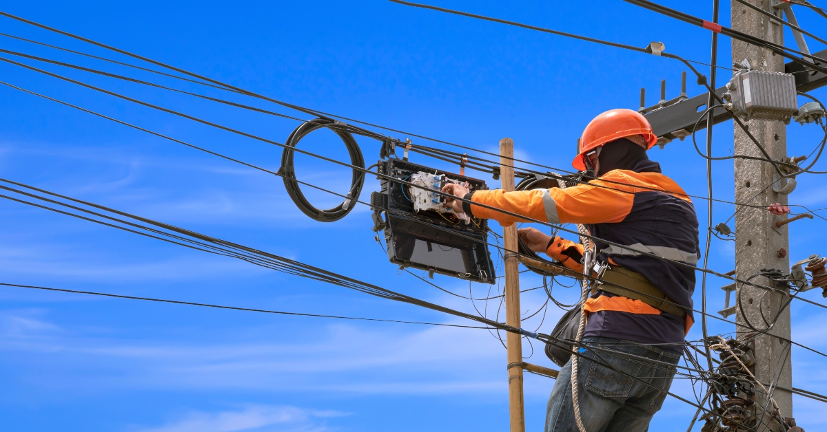 technician on wooden ladder is installing fiber optic system