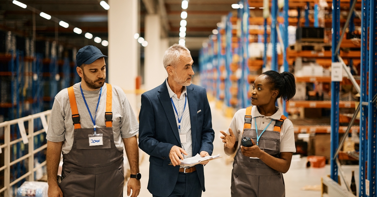 warehouse workers talk to their manager while walking 