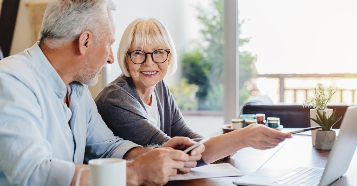 senior couple doing home finances using laptop indoors