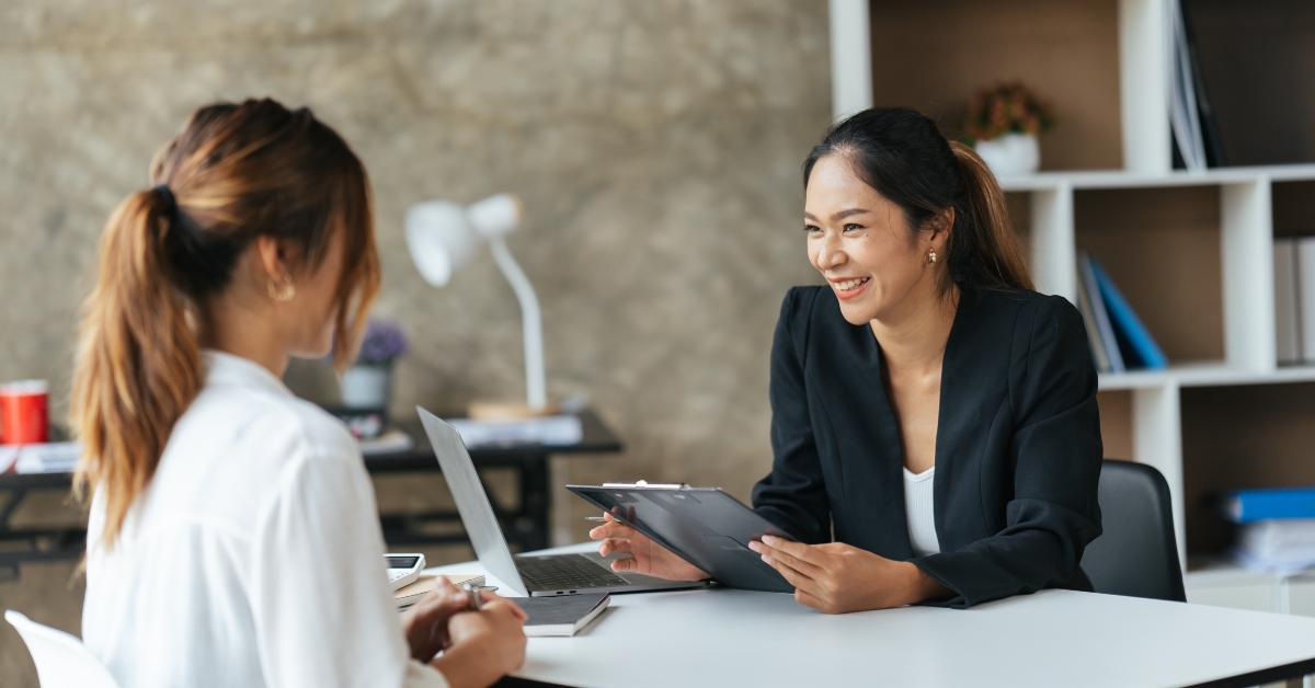 two asian women with laptop in open space office