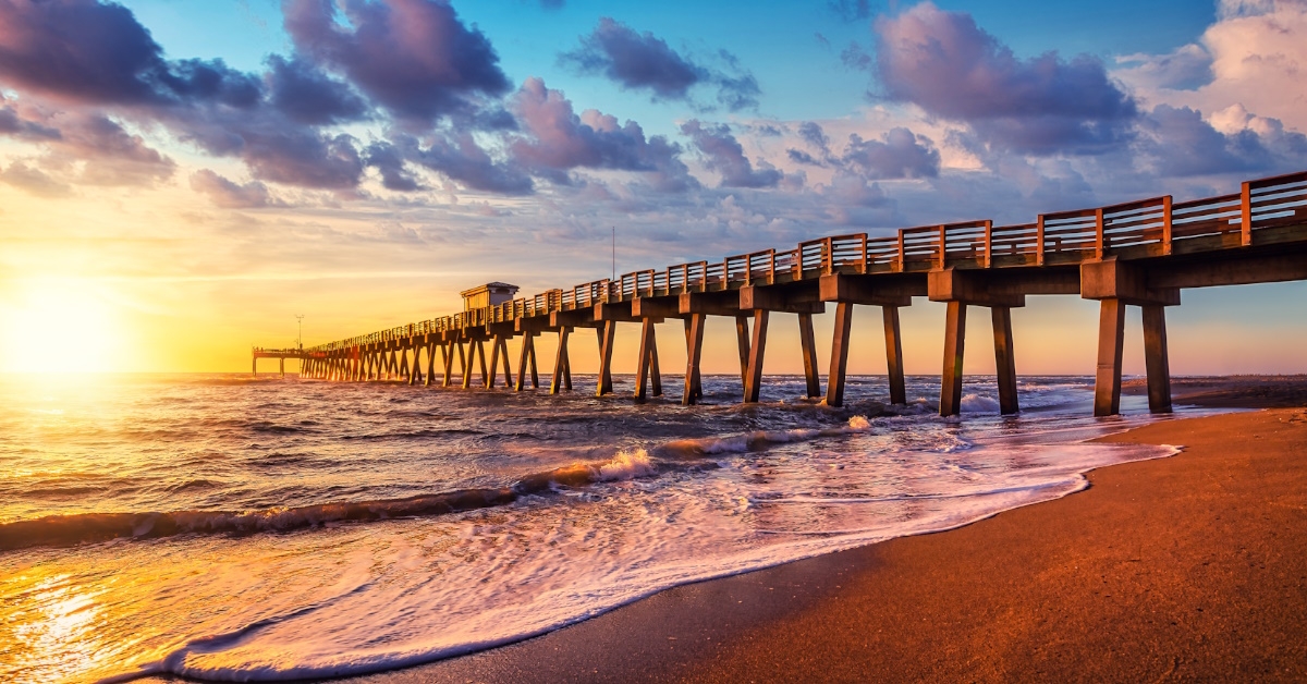 famous pier of venice with waves crashing the shoreline at sunset time