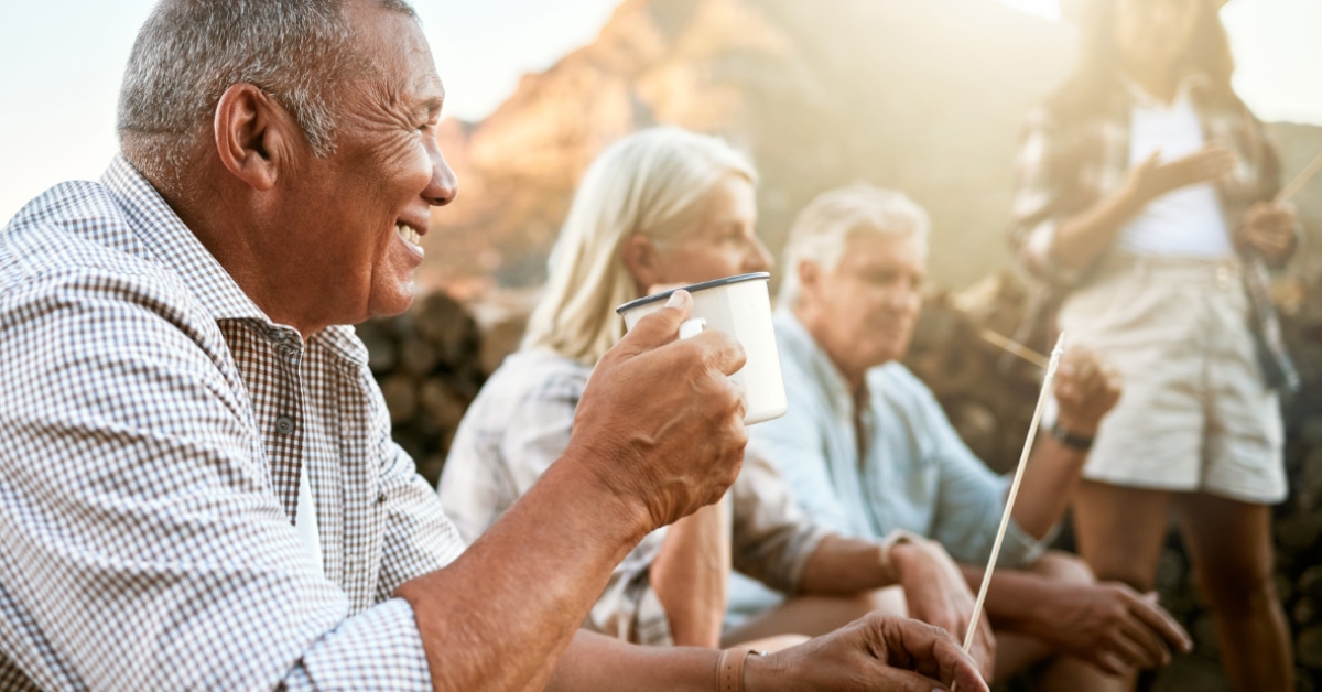 multi ethnic senior friends having fun while camping outdoors