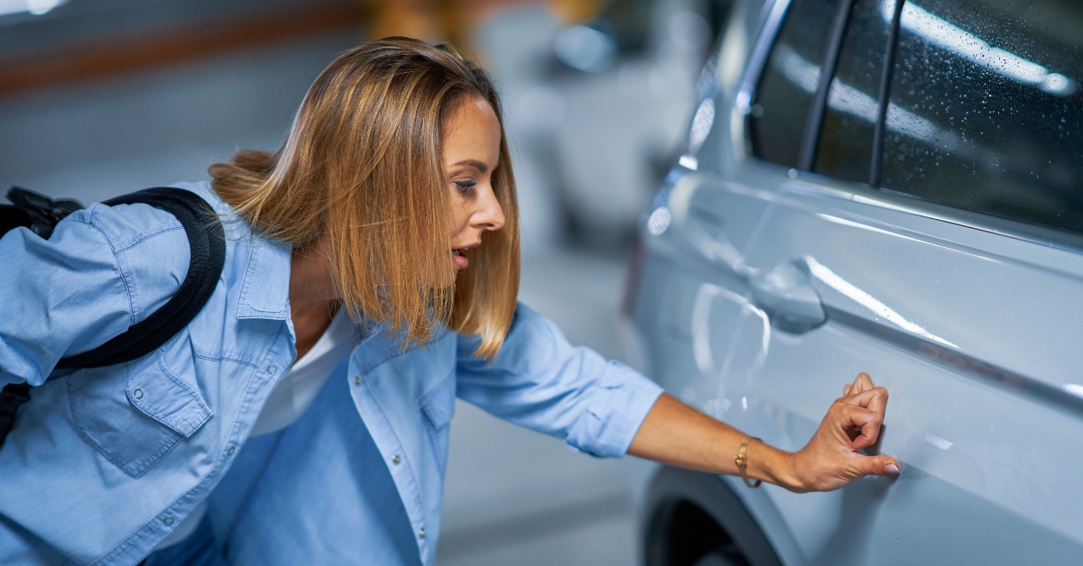 woman with scratched car at underground parking lot