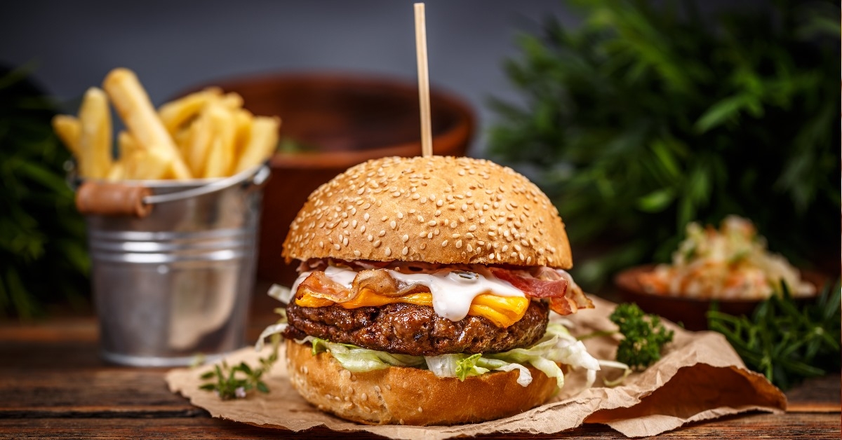 Cheese burger with large beef patty and finger fries.