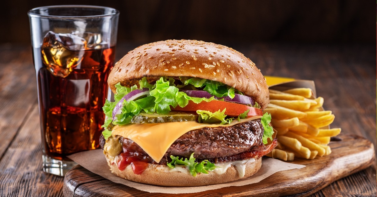 delicious burger with cola and potato fries on a wooden table 
