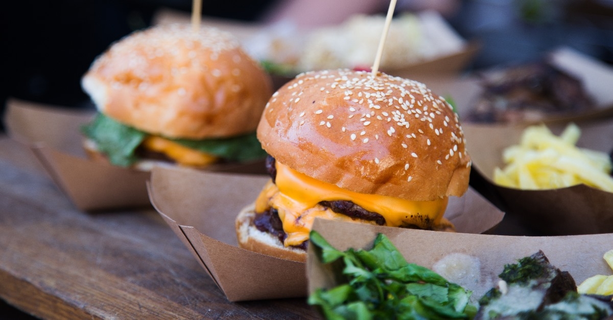 Fresh street food burgers with a lot of cheese and lettuce are ready to serve