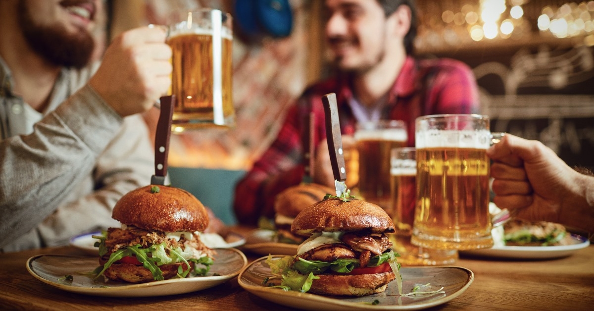male friends enjoying burgers with bear in a bar pub