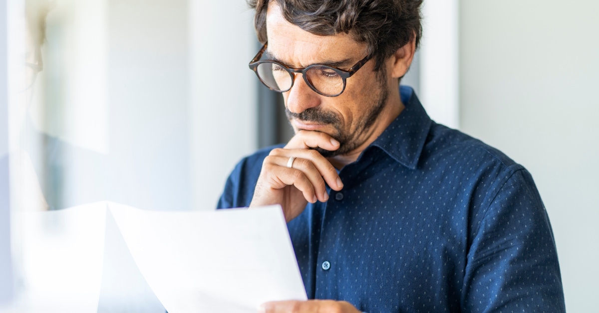 businessman wearing glasses reading documents at office
