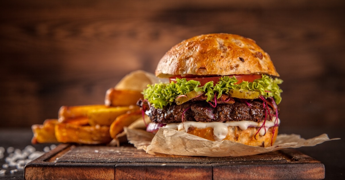 hamburger with lettuce, cheese, and some fries