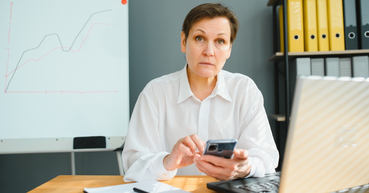 older businesswoman busy reading a text message
